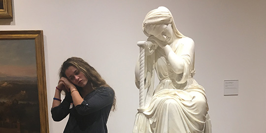 EMory student mimics a statue in a museum